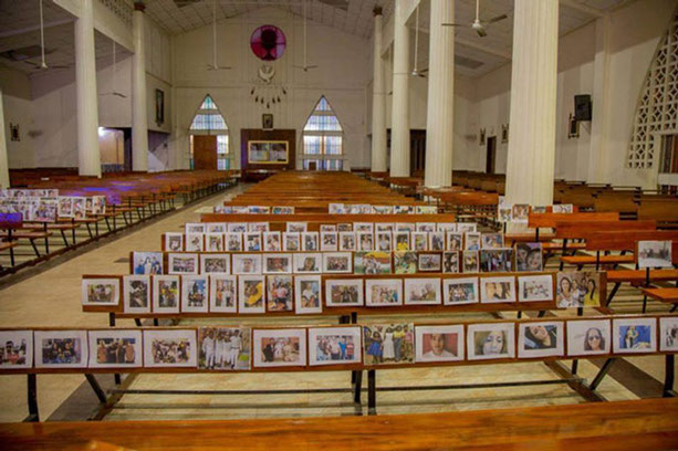The empty church with the photographs of parishioners attached to the benches.